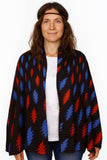 Woman wearing a black cardigan with red and blue abstract pattern on a white background