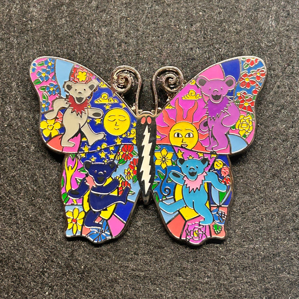 Colorful butterfly-shaped pin with cartoon characters on a textured surface