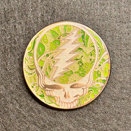 Circular object with a design of a skull and lightning bolt on a textured gray background