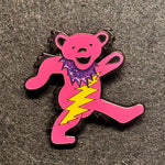 Pink cartoon-style bear with a purple heart and yellow lightning bolt on a gray surface