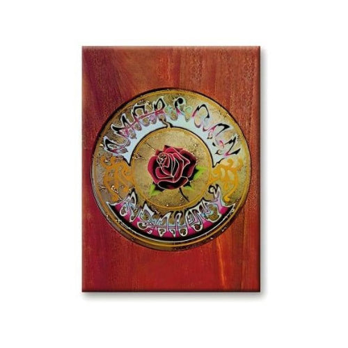 Decorative plaque with a rose design on a wooden background