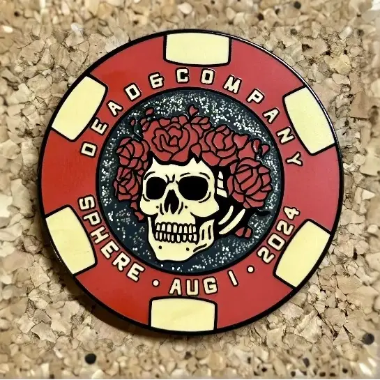 Red poker chip-style pin featuring a skull with roses design and ’Dead & Company’ text.