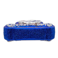 Blue glittery rectangular object with a white design on a white background