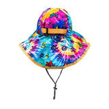 Tie-dye bucket hat with tan trim and adjustable chin strap.