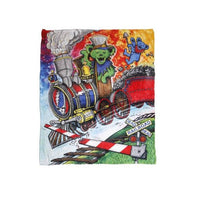Colorful blanket with a train and bear design on a white background