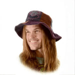 A person wearing a brown corduroy bucket hat with long hair and a warm smile.