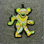 Colorful pendant of a Grateful Dead dancing bear decorated with psychedelic yellow and green patterns.