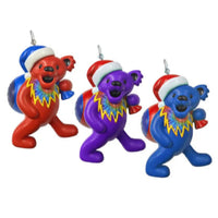 Three colorful bear ornaments with Santa hats on a white background