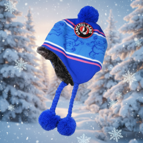 Blue winter hat with pom-poms on a snowy background
