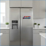Stainless steel refrigerator in a modern kitchen with a colorful toy truck magnet on the door.