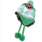 Green and white beanie with embroidered turtle pattern, faux fur trim, braided ear flaps ending in green pom-poms, and a circular peaceful dead logo patch on the crown.