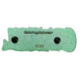 Green textured object with two black dots on a brown background