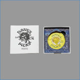 Dave's Picks trading card deck packaging shown open, with a white outer box featuring black logo text on the left and the inner blue card deck box with a round gold coin insert on the right, photographed on a brown surface.