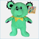 Green plush toy with a yellow shirt on a white background