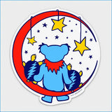 Blue grateful dead bear sticker with red scarf and lightning bolt-patterned pups under a crescent moon adorned with yellow stars.
