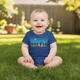 Baby sitting on grass wearing a blue onesie with a colorful design.