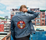 Blue denim jacket with a circular patch featuring a smiling uncle sam wearing sunglasses and a red, white, and blue hat.