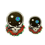 Two skull stickers with floral designs and space-themed design on a dark surface