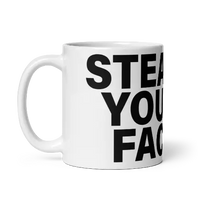 White mug with black text.