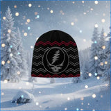 Black beanie with red and white design against a snowy forest background