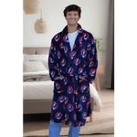 Man wearing a blue robe with red and white patterns in a bedroom setting