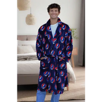 Man wearing a blue robe with red and white patterns in a bedroom setting