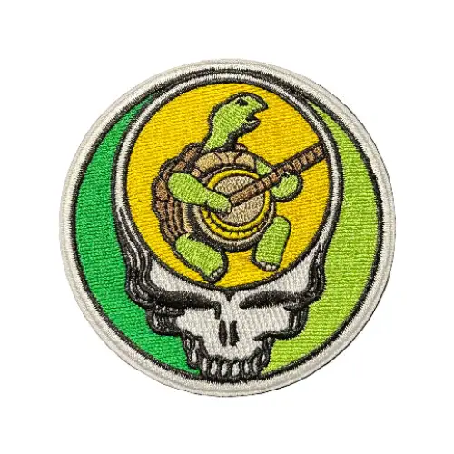 Circular patch with a turtle and shell design on a textured black background