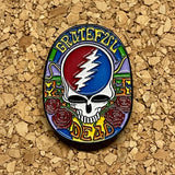 A colorful enamel pin featuring the iconic grateful dead skull with a red and blue lightning bolt, surrounded by roses and ornate patterns in vibrant hues.