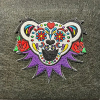 Colorful sugar skull-style bear patch with purple spikes and red roses.