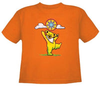 Orange t-shirt featuring a cartoon yellow bear balancing a colorful ball.