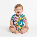 Baby wearing a colorful onesie with cartoon bears on a white background