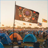 A black grateful dead flag featuring a purple skull with roses and the band’s logo, waving in the breeze.