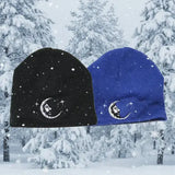 Black and blue beanies with moon and star designs on a white background