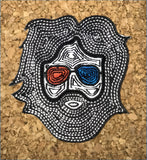 Black embroidered patch featuring a stylized face with long hair, red and blue 3d glasses, and white geometric patterns.