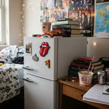 Red enamel pin featuring the iconic rolling stones tongue and lips logo with black outlines.