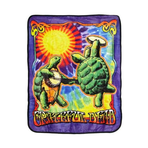 Colorful blanket with turtles playing banjo and turtle shell, and 'Grateful Dead' text on a tie-dye background.